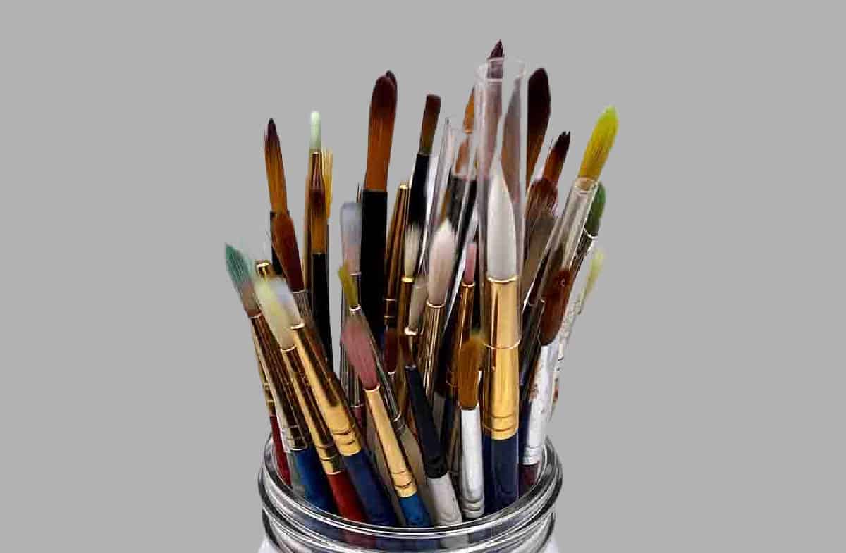 A glass jar full of artists' brushes.