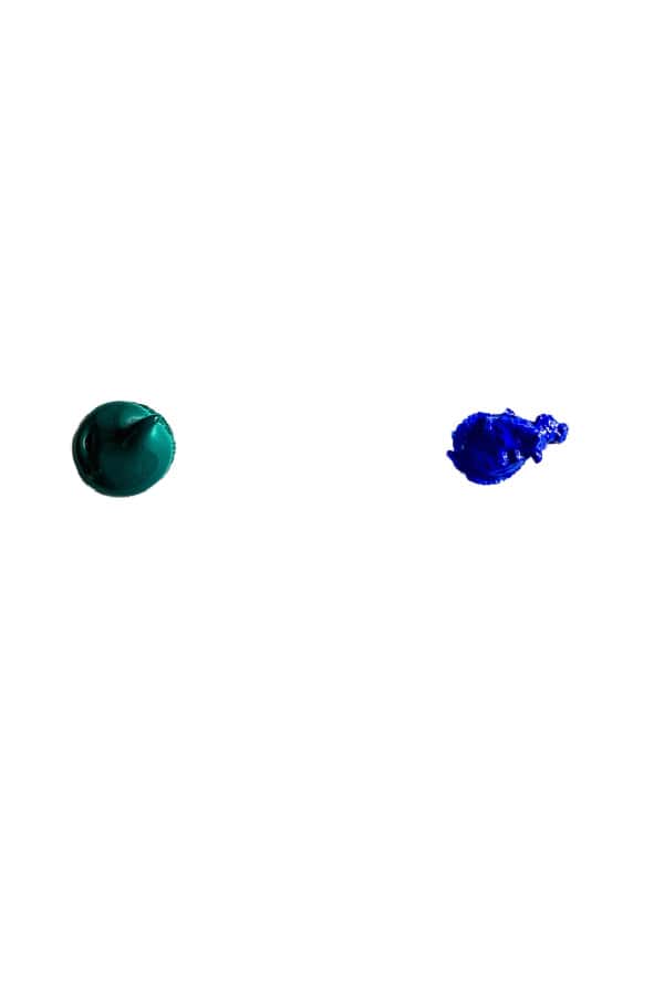 Dots of green and blue paint on a white background.